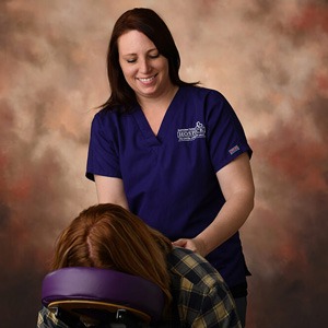 woman massage therapist giving chair massage