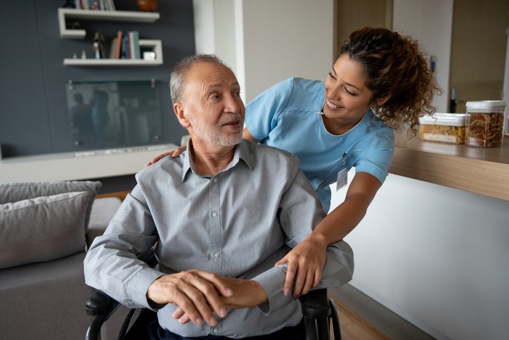 Senior man with ALS in a wheelchair receiving care at home